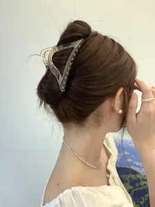 Detail of a large amber triangle hair claw clip styled on a classic bun hairstyle