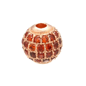 Macro shot of rose gold copper sphere bead with pave orange crystals for DIY jewelry
