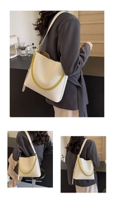 Detailed view of the white shoulder bag with golden chain and soft leather texture