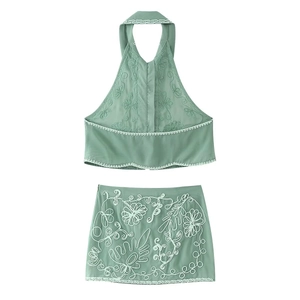 Détails de broderie sur l'ensemble deux pièces vert clair avec haut licou et jupe