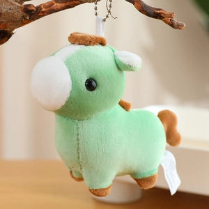 Detail of mint green plush pony charm with metal bead chain hanging on a branch