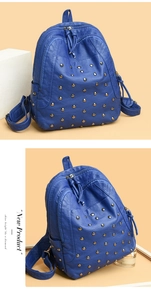 Detail of blue lychee leather backpack featuring gold metal rivets and dual zippers