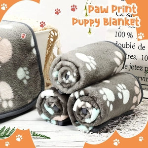 Detail of grey flannel puppy blankets with white paw prints and fine piping craftsmanship