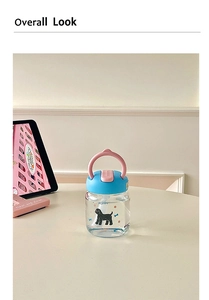 Close-up of portable glass water bottle featuring cute puppy pattern and pink handle