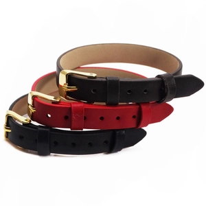Detail of 10mm leather wristbands in black and red with elegant gold metal buckles
