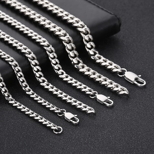 Detailed macro of silver Cuban chains in three sizes with lobster clasps and metallic shine