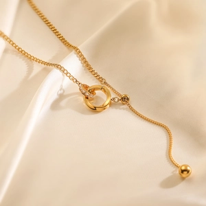 Elegant gold-plated geometric double ring necklace with cubic zirconia on silk background