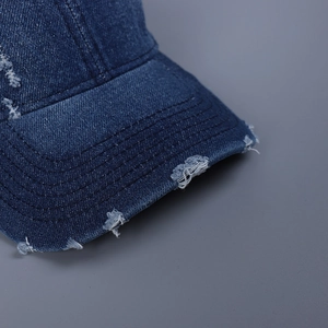 Distressed dark blue denim baseball cap with vintage frayed edges and torn details