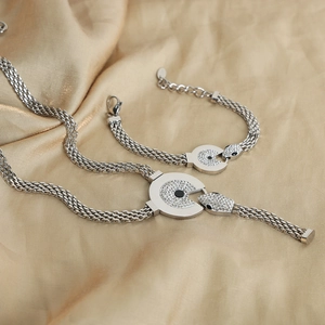 Silver snake-shaped jewelry set with necklace and bracelet on champagne satin