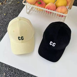 Detail of embroidered CC letters on cotton baseball caps in yellow and black