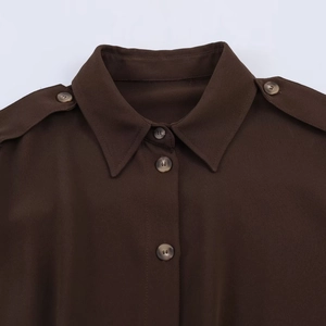 Détail de la chemise marron à manches longues avec pattes d'épaule et boutons