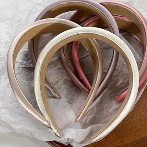 Detailed top view of wide satin headbands with anti-slip lining in pearlized colors