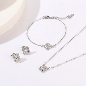 Detailed set of silver clover jewelry with sparkling zircon necklace, bracelet and earrings