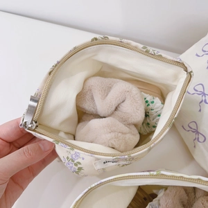 Détail de la trousse à maquillage en toile fleurie montrant le rangement intérieur