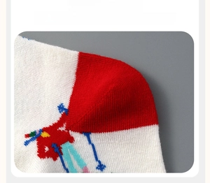 Detail of reinforced red heel on white cotton crew socks with colorful knit pattern