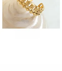 Macro shot of gold chain link ring with metal beads on a pearlescent spiral base