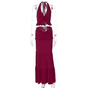 Detail of burgundy two-piece set featuring halter top with twist and ruffled maxi skirt