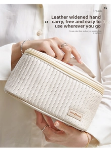 Detail of cream quilted PU leather makeup bag with wide handle and LOVE PEACE patch