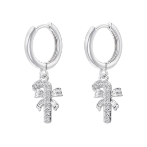Detailed macro shot of silver Christmas candy cane earrings with crystal bows and zircons