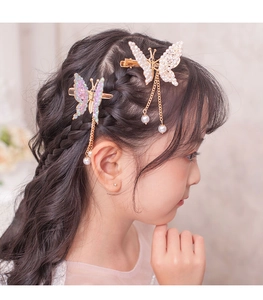 Close-up of butterfly hair clip with pearly tassels and sparkling pink and white wings
