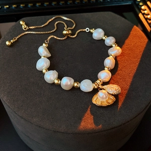 Detail of freshwater pearl bracelet with shell pendant and adjustable gold slider clasp