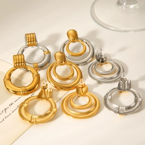 Detailed view of vintage gold and silver layered geometric round hoop earrings on paper