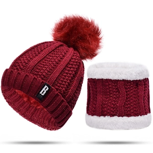 Detailed close-up of burgundy knitted beanie and fleece neck warmer set with faux fur pom