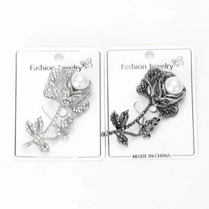 Detailed view of vintage rose brooches with sparkling rhinestones and white pearls