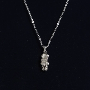 Detailed view of astronaut pendant with cat-eye stone and Hug Me engraving on necklace