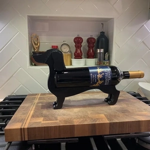 Macro detail of a black wooden dachshund wine bottle holder on a kitchen countertop