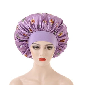Close-up of purple butterfly print sleep bonnet with wide elastic band on a model