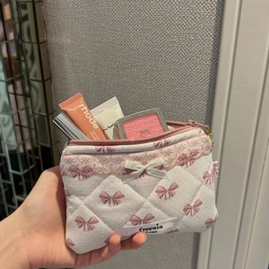Detail of pink plaid quilted makeup bag with lace trim and ribbon bow decoration
