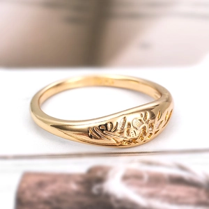 Macro shot of 925 stamp and hollow leaf pattern on gold-plated sterling silver ring