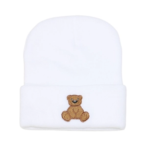 Close-up of white knitted beanie featuring detailed brown bear embroidery on the cuff