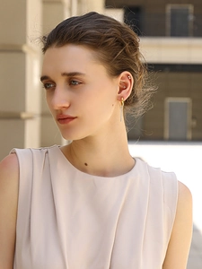 Close-up of elegant 18K gold-plated chain tassel earrings with sparkling rhinestones on model