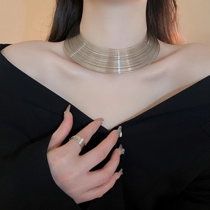 Close-up of layered silver wire choker necklace and matching ring on model