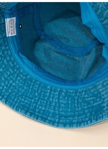 Vue détaillée de l'intérieur d'un bob bleu en coton avec coutures et étiquette de lavage