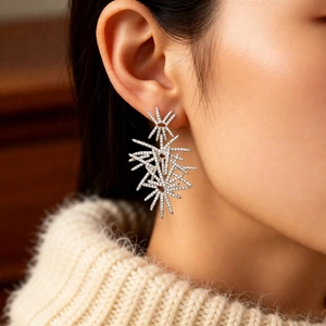 Close-up of starburst zircon earrings featuring a polished silver finish on a model
