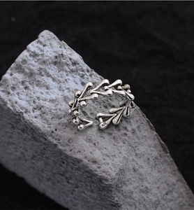 Macro detail of S925 sterling silver dragon bone heart ring on grey natural rock
