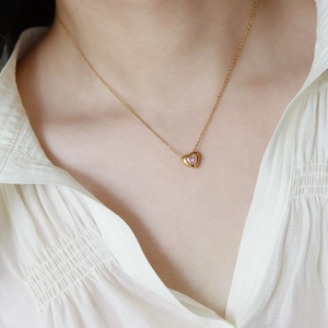 Elegant 18K gold-plated necklace with a pink heart pendant worn by a model