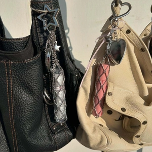 Detail of silver mesh lipstick holders with heart and star charms on a handbag
