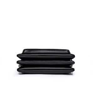 Detalle lateral de bolso bandolera negro con diseño de tres capas y piel suave