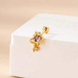 Detailed close-up of golden planet earring with purple zircon stone on white pedestal