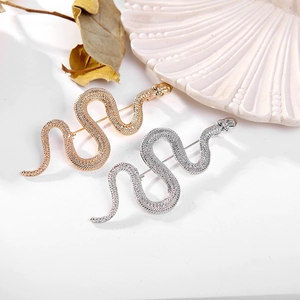 Vintage gold and silver snake brooches with realistic scale textures and crystals