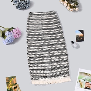 Dettaglio della maglia a onde e dell'orlo con frange color crema sulla gonna boho