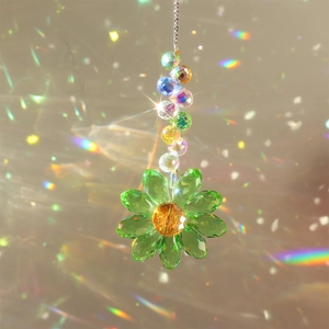 Macro shot of green crystal sunflower suncatcher creating rainbow reflections on window