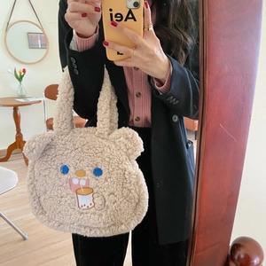 Close-up of beige plush bear tote bag with cute embroidery in a lifestyle setting