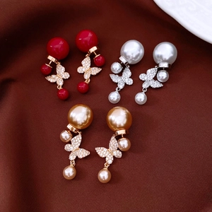Vue détaillée de boucles d'oreilles papillon en perles plaquées or 18 carats en trois couleurs