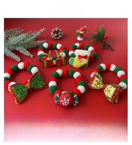 Macro shot of festive Christmas pet collars with pom-poms, reindeer antlers, and bows
