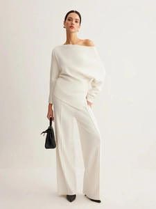 Chic white off-shoulder asymmetrical knitted top with matching wide-leg trousers